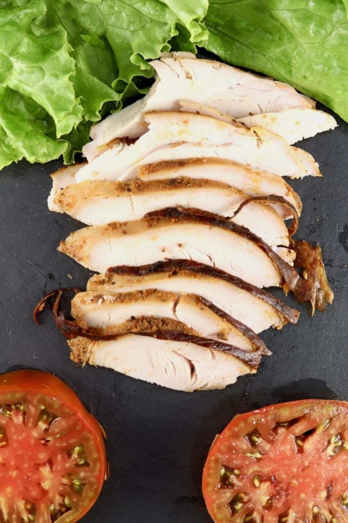 Sliced turkey with lettuce and sliced tomatoes.