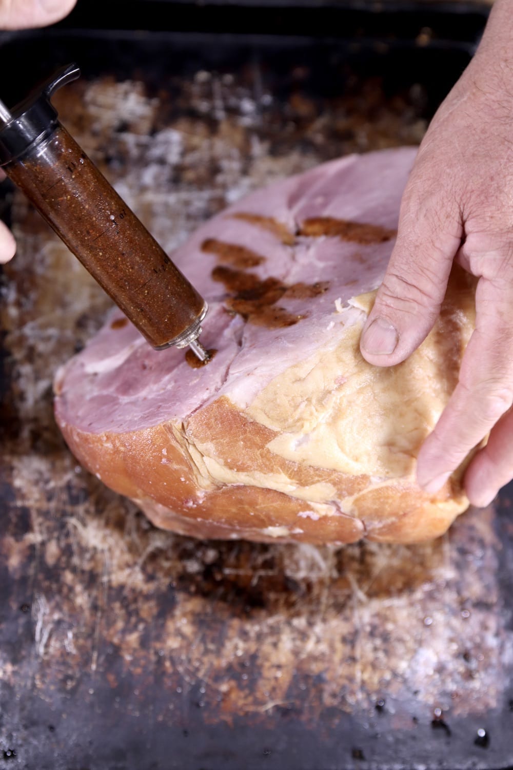 Injecting maple glaze into ham