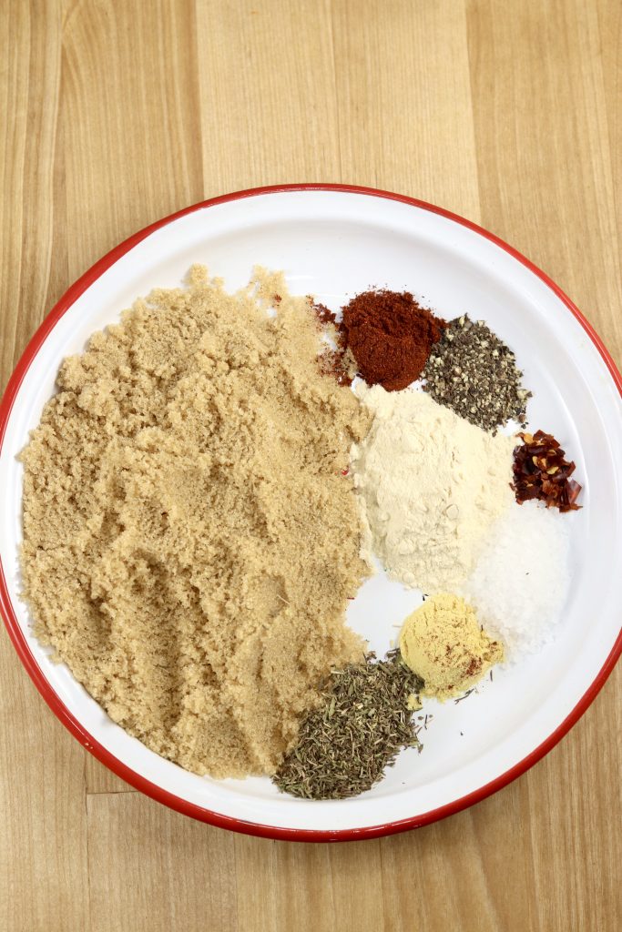 Brown sugar and spices for ham glaze in a red rimmed white plate