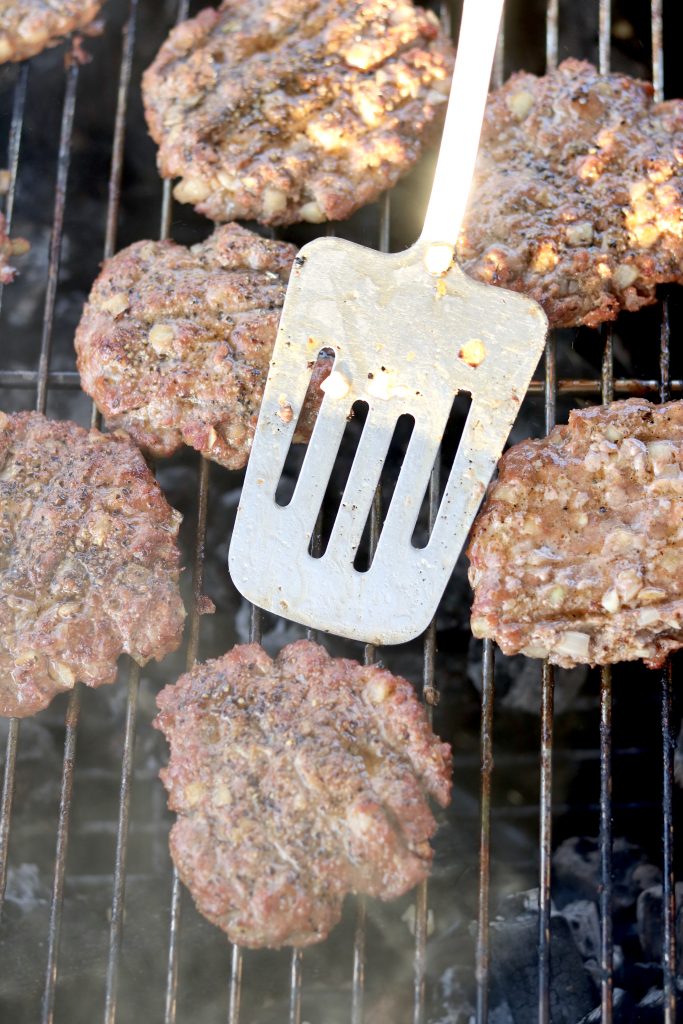 Flipping burgers on a charcoal grill
