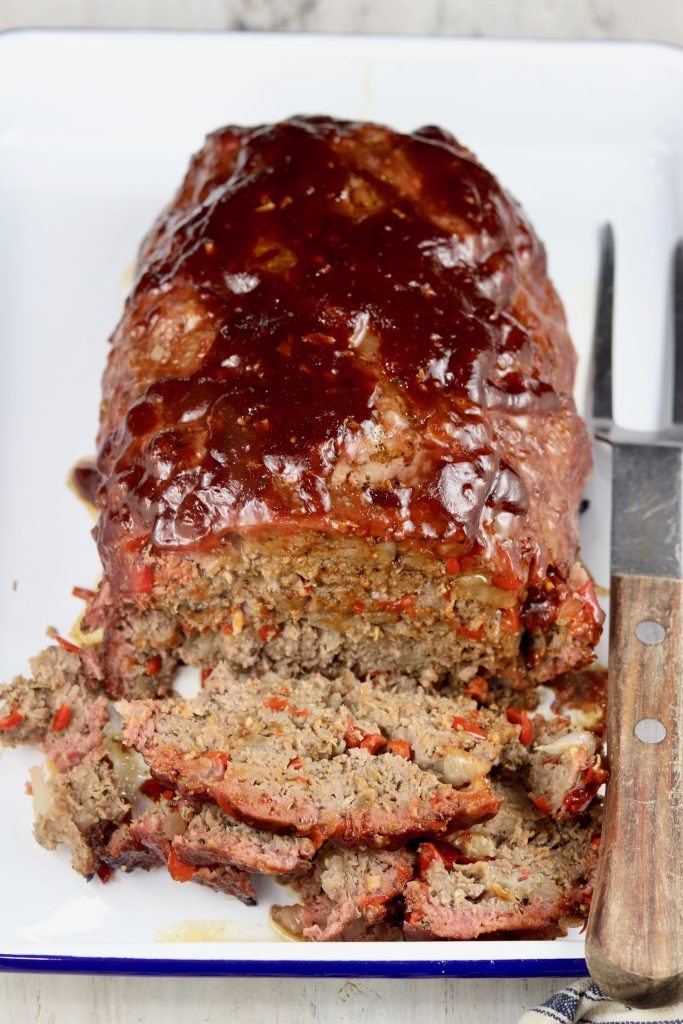 BBQ Meatloaf with 2 slices, sliced on a tray with a meat fork
