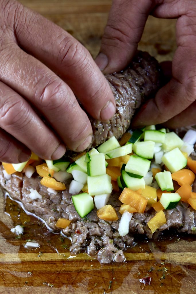 Rolling steak with vegetables for grilling