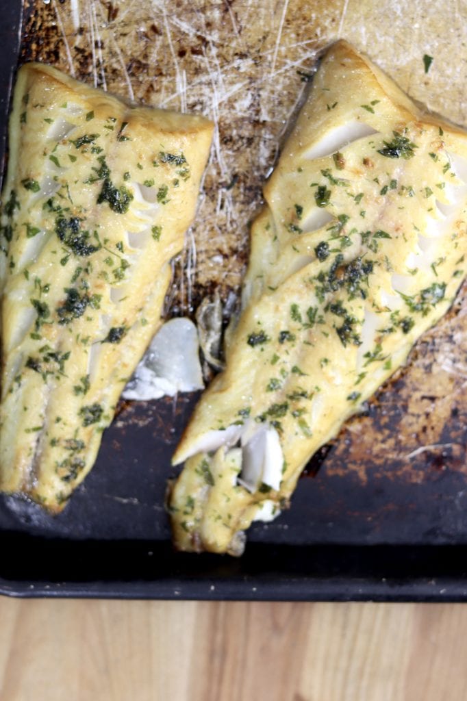 Grilled Sablefish with garlic and herb butter on a baking sheet