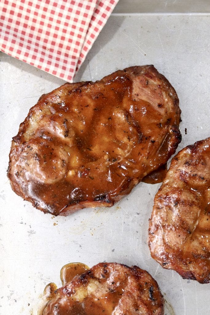 Grilled Pork steaks on a baking sheet with red napkin