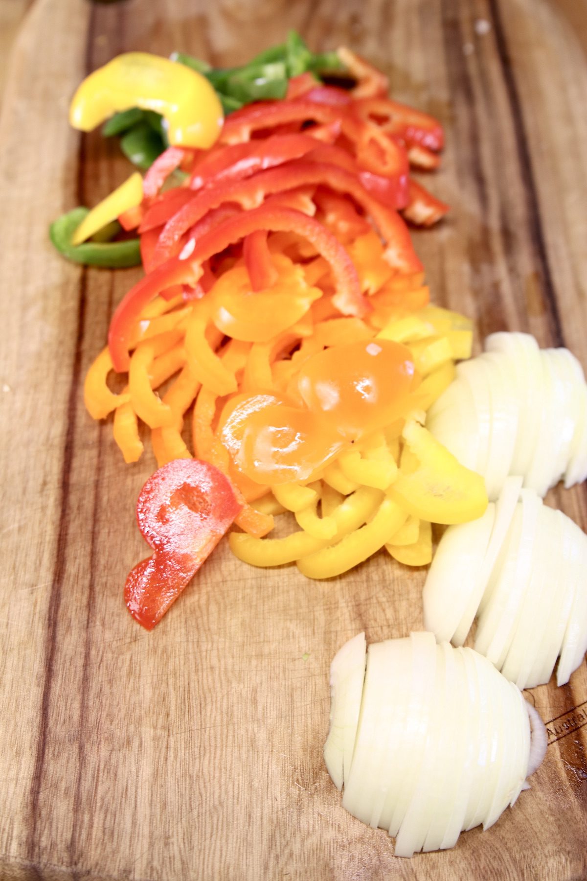 bell peppers and onions sliced on a cutting board