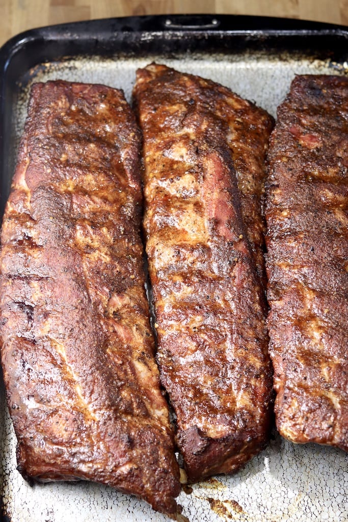 Baking sheet with 3 racks of grilled baby back ribs
