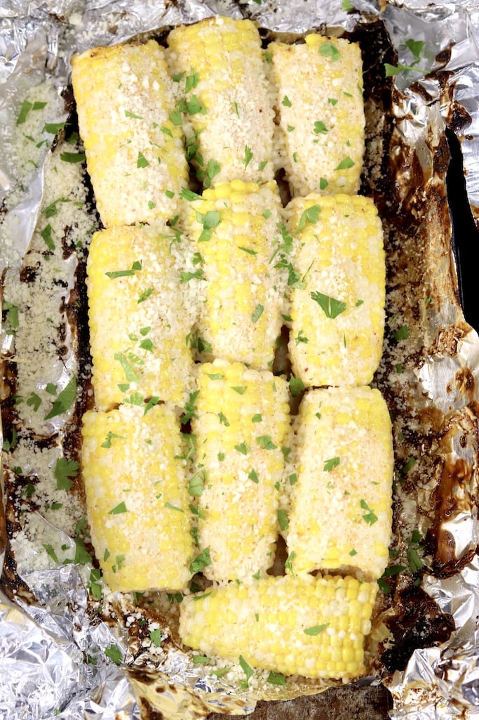 Foil packet of corn on the cob, half ears with cilantro and cotija cheese