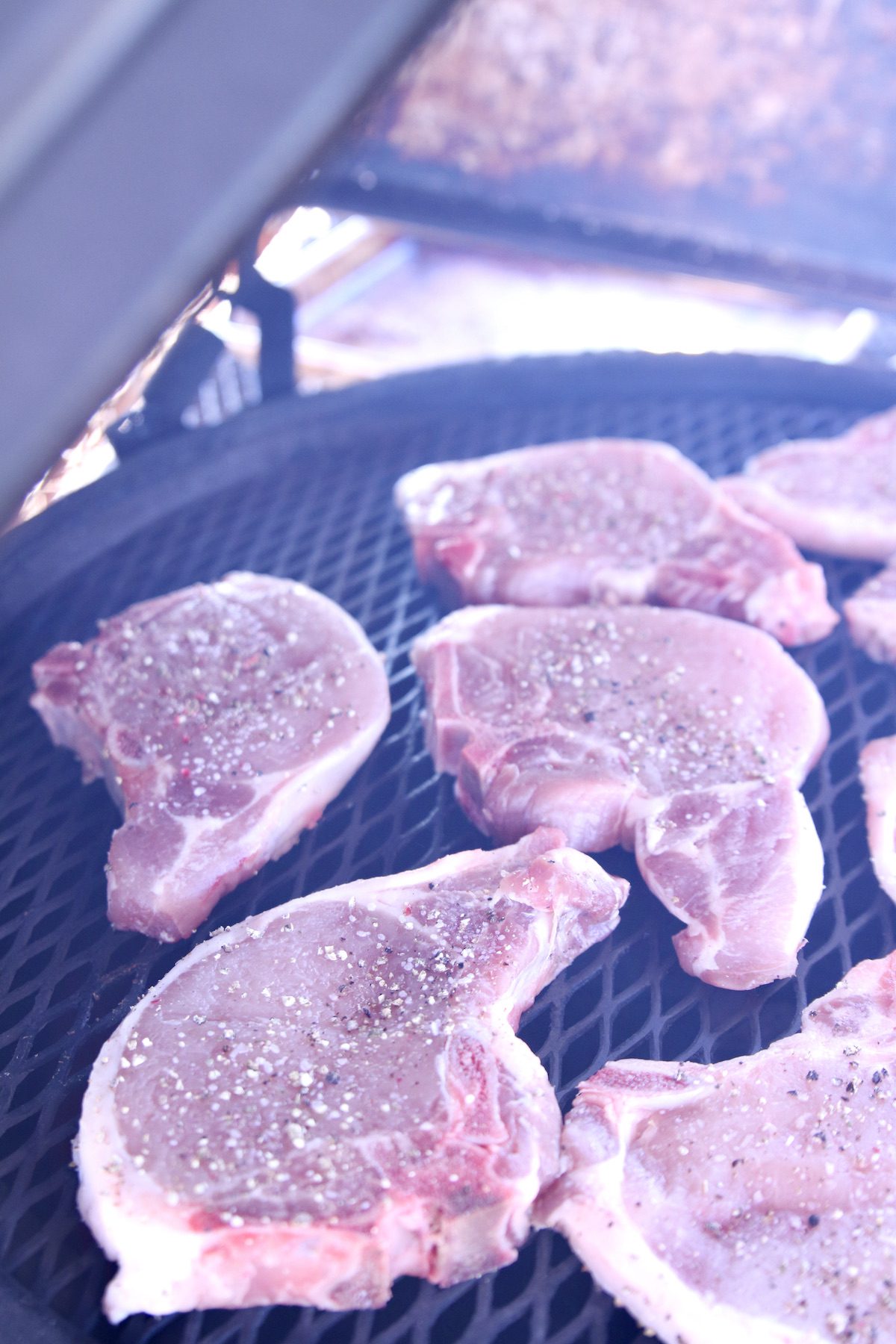bone in pork chops on a grill.
