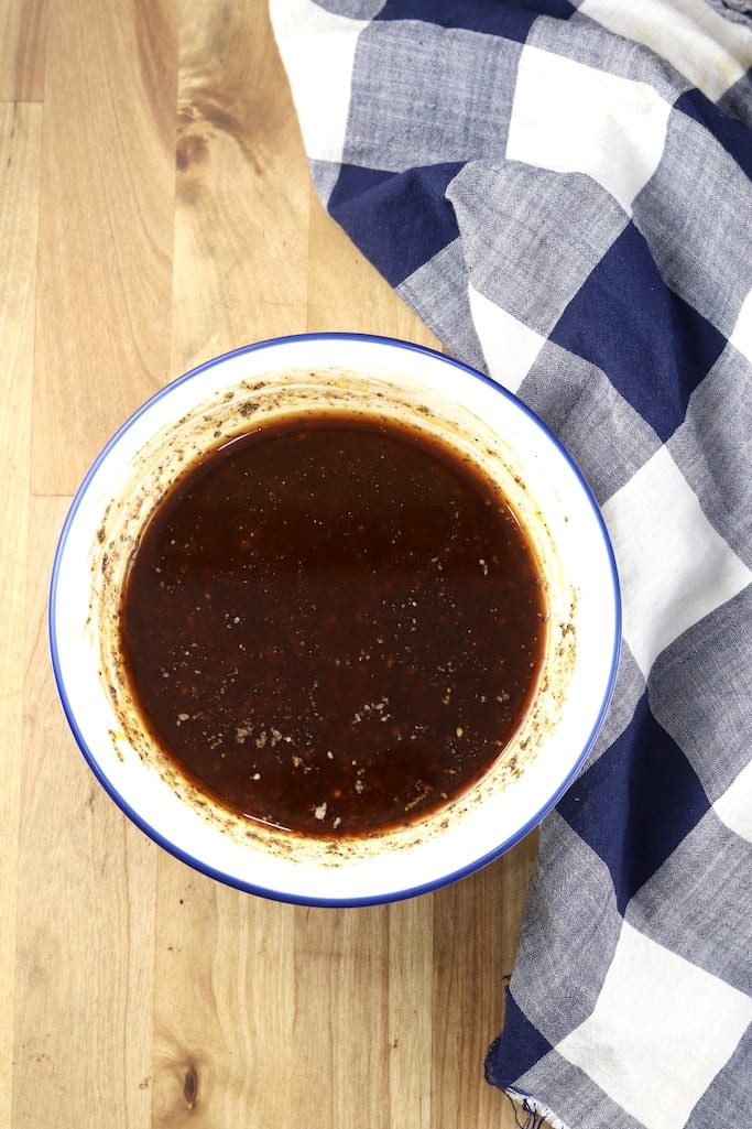 Balsamic Marinade for chicken in a bowl blue check towel on a wood surface