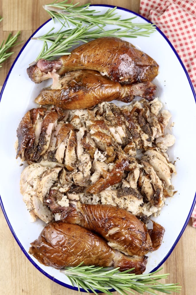 Platter of smoked chicken, sliced and legs with rosemary sprig garnish
