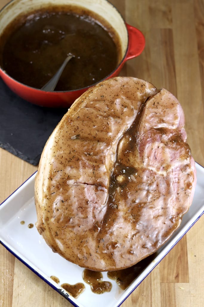 Glazed ham on a baking sheet, Coca-Cola glaze in a saucepan