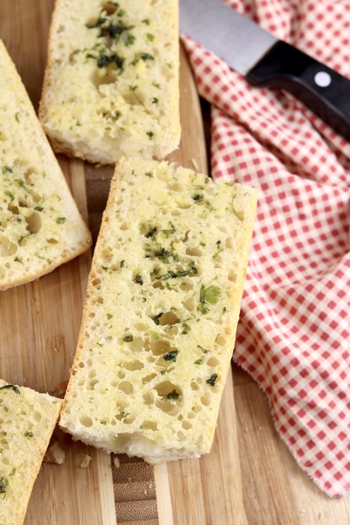 Garlic Bread slices on cutting board with red check napkin