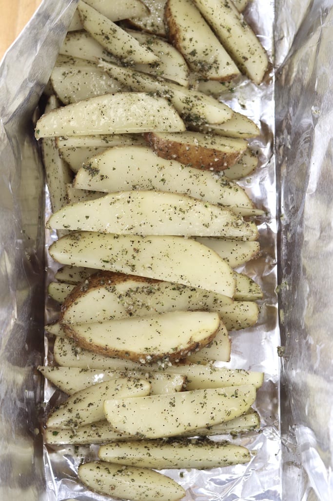 Foil packet with potato wedges with garlic rosemary butter