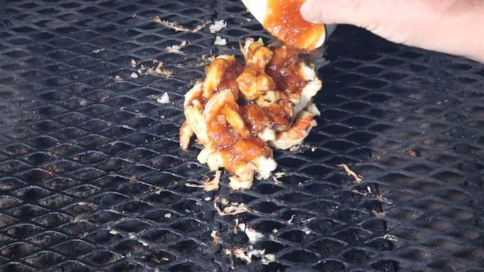 Pouring bbq sauce over shrimp on the grill