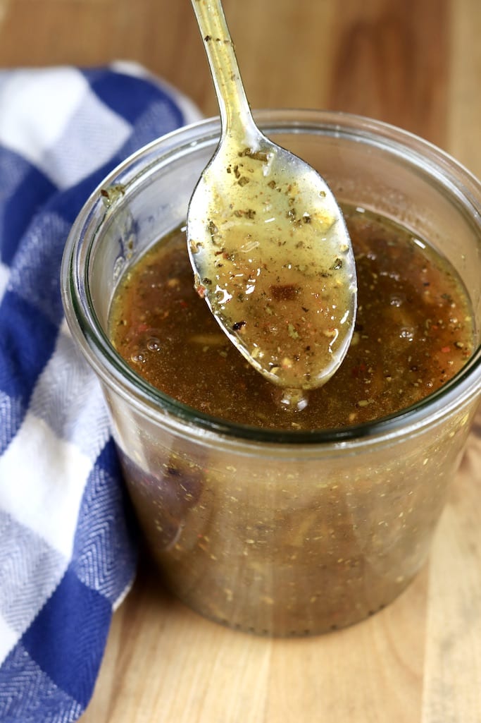 Orange BBQ Sauce for grilling pork chops - spoon dipping into jar
