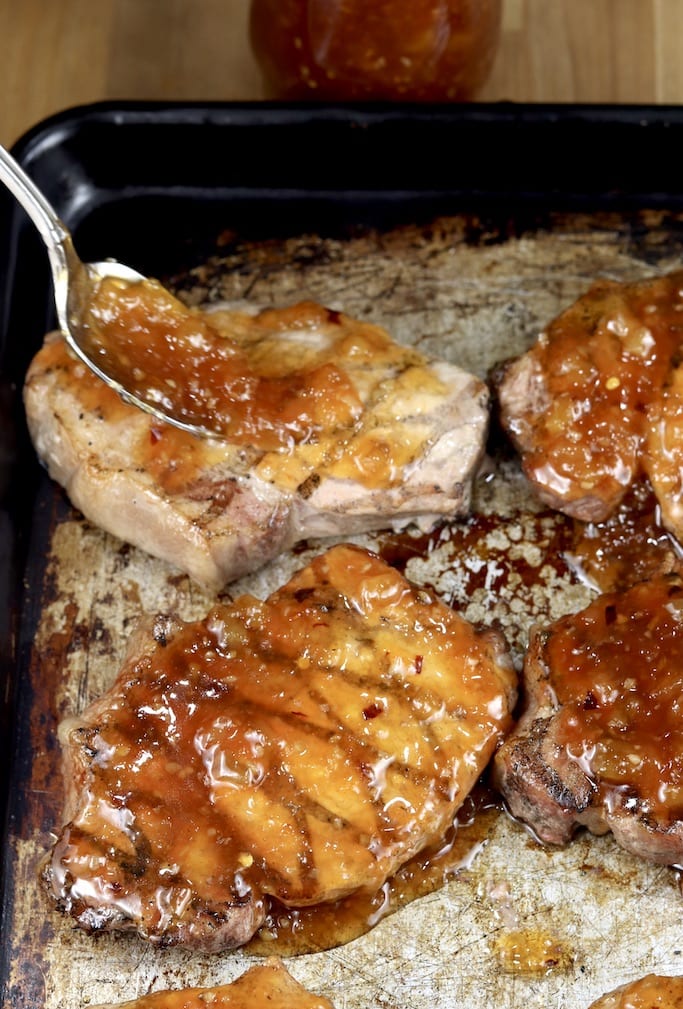 Covering grilled pork chops with pineapple bbq sauce