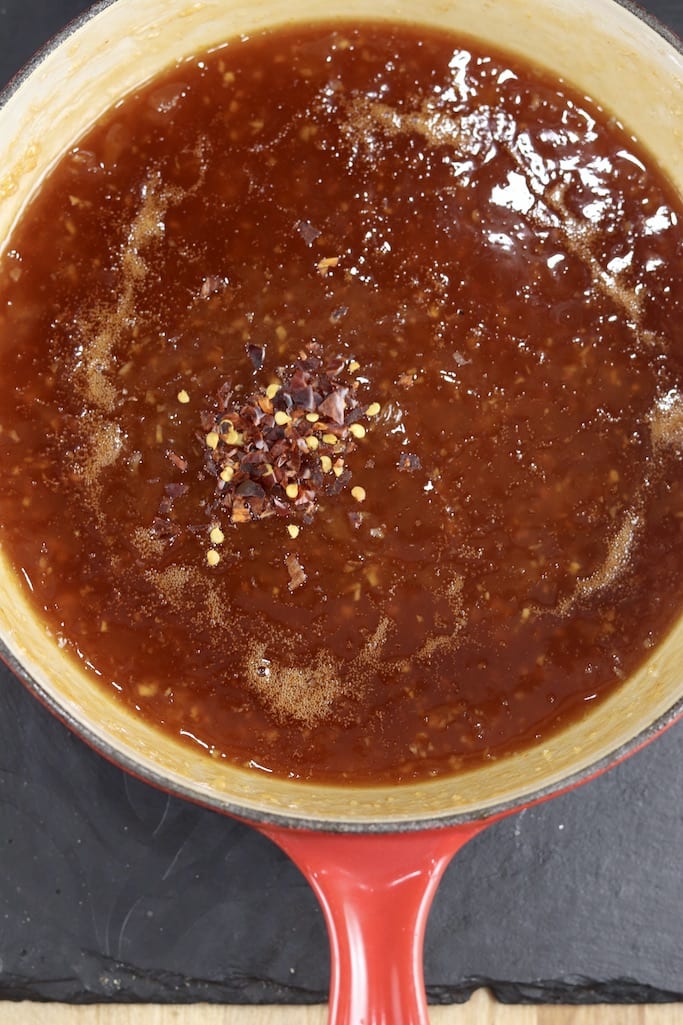 chili flakes in pan of pineapple bbq sauce