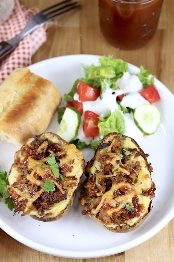 Smoked Pork Stuffed potatoes on a plate with salad and bread