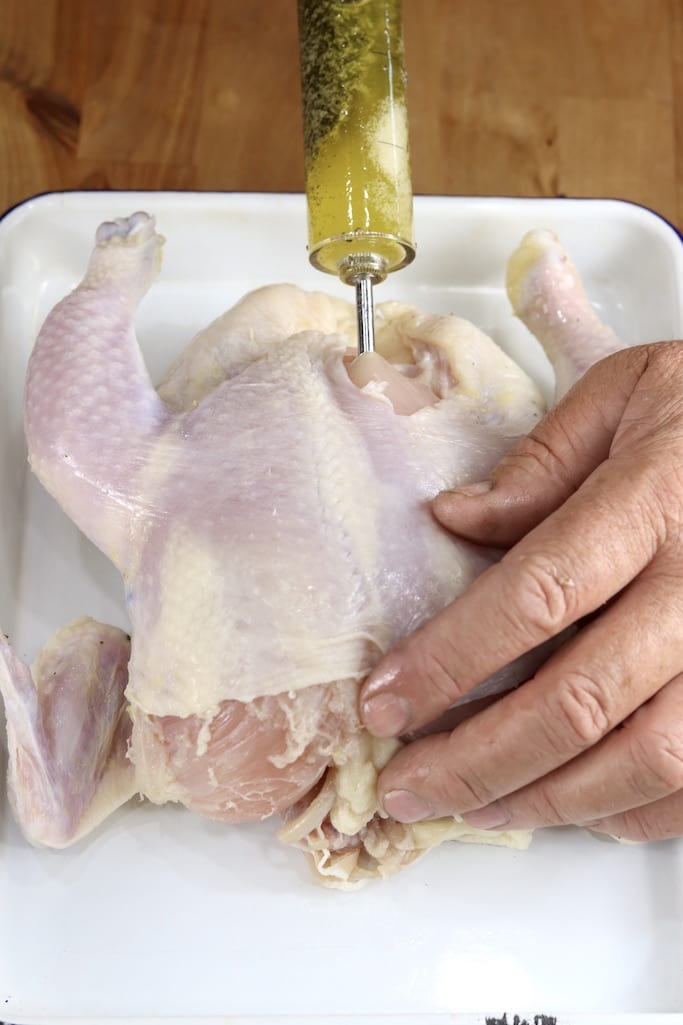 Injecting herb butter into breast of a whole chicken