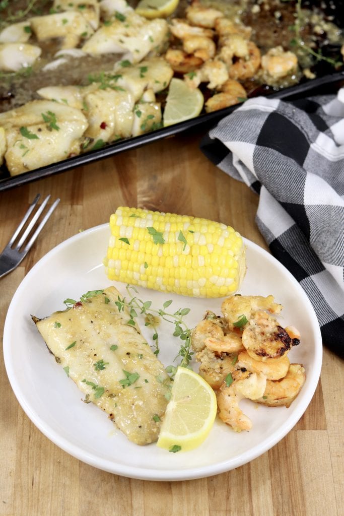 Plate of lemon garlic fish and shrimp with corn on the cob