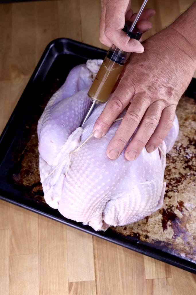 injecting apple cider marinade into a whole turkey