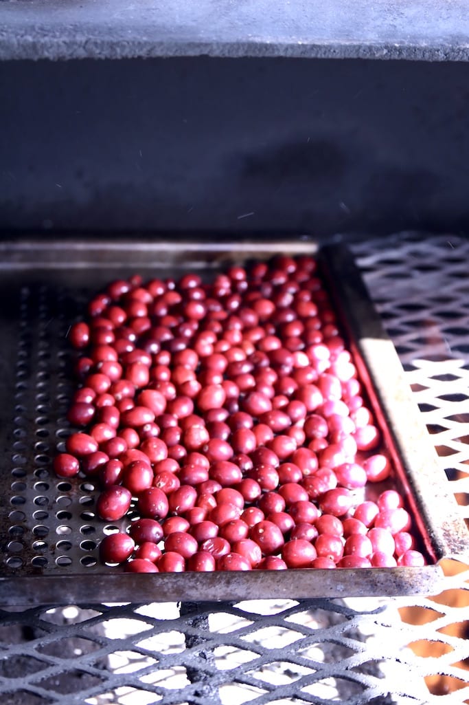 fresh cranberries on a grill pan on a grill