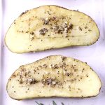 Garlic Butter Baked Potatoes with herbs, 2 halves on a white plate