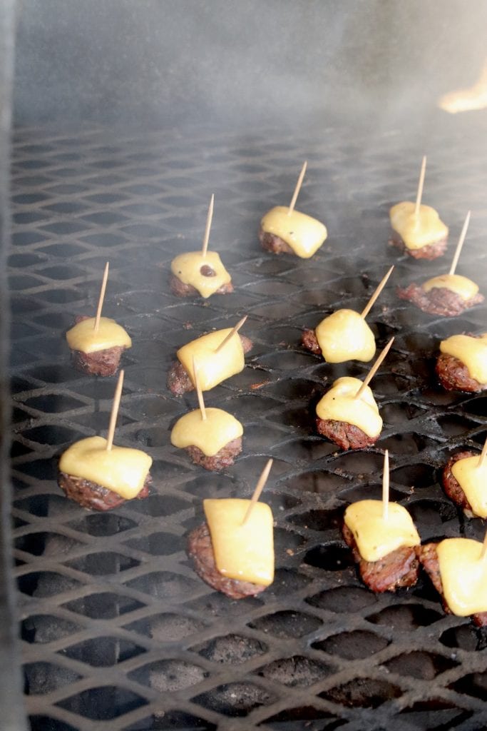 steak and cheese bites on toothpicks on a grill