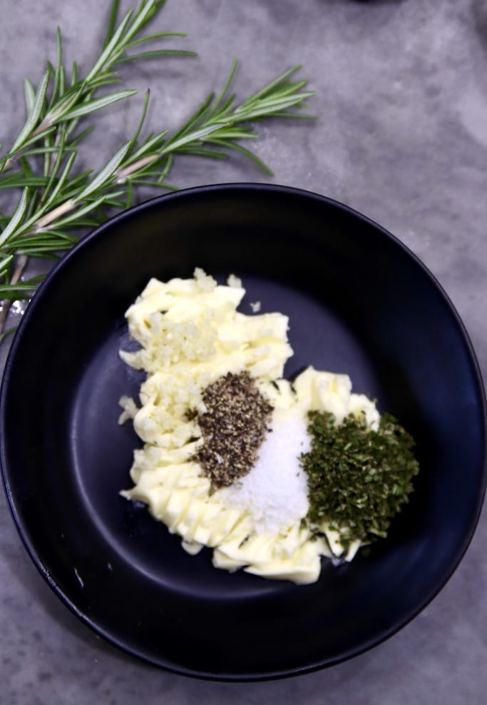 Bowl with butter, rosemary, garlic, salt and pepper