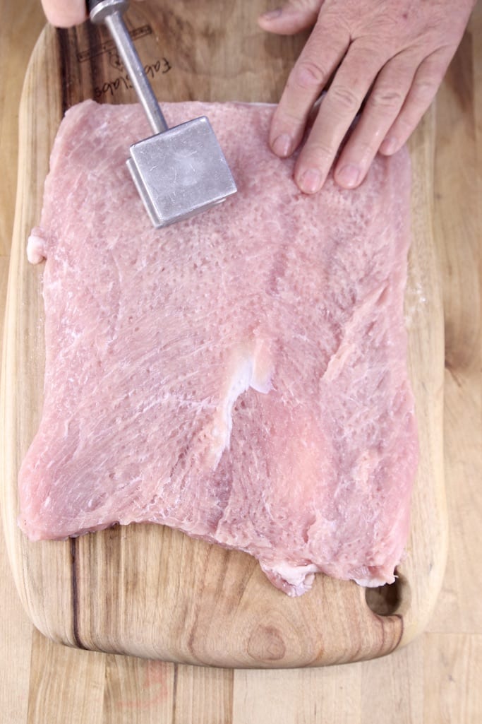 flattening a pork tenderloin with a meat mallet