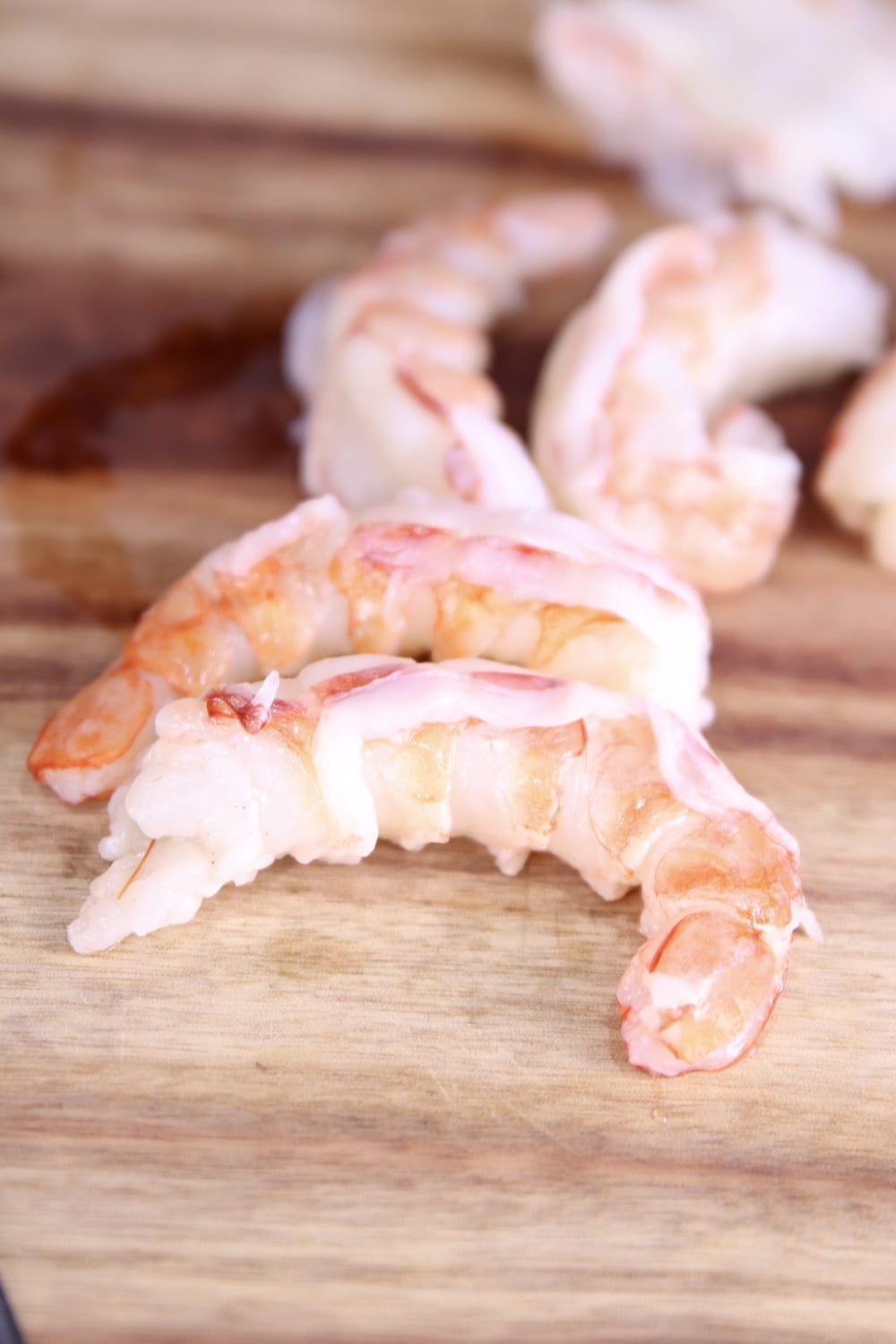 peeled and deveined shrimp on a wood cutting board
