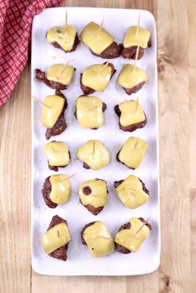 Steak and Cheese Bites on toothpicks served on an rectangle white platter - overhead view