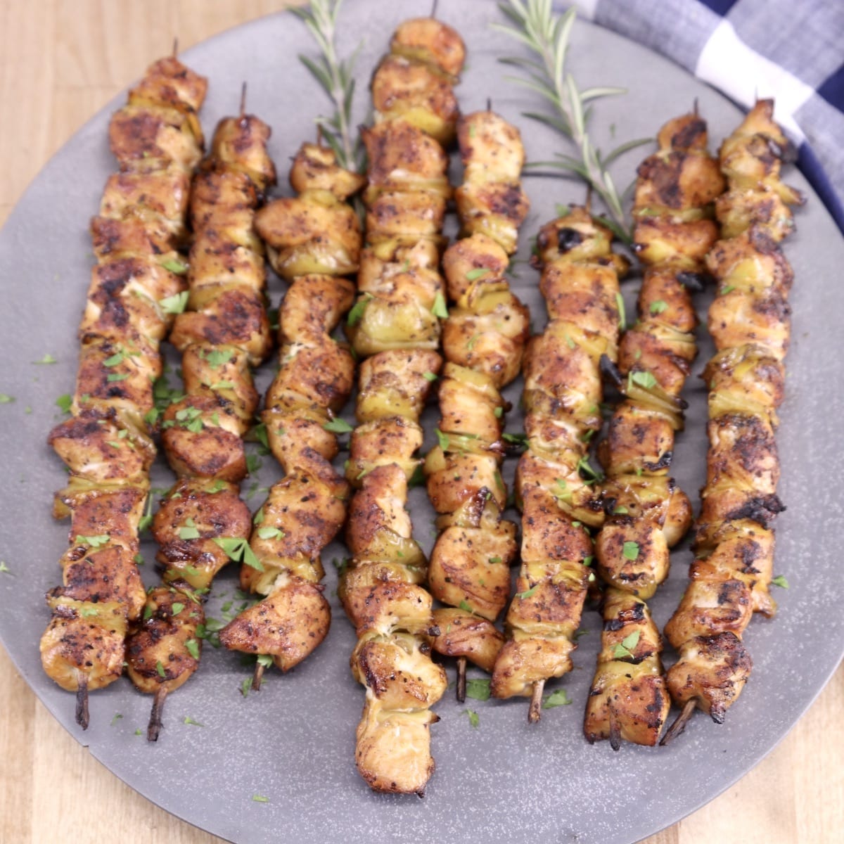 grilled Chicken skewers on a gray round platter
