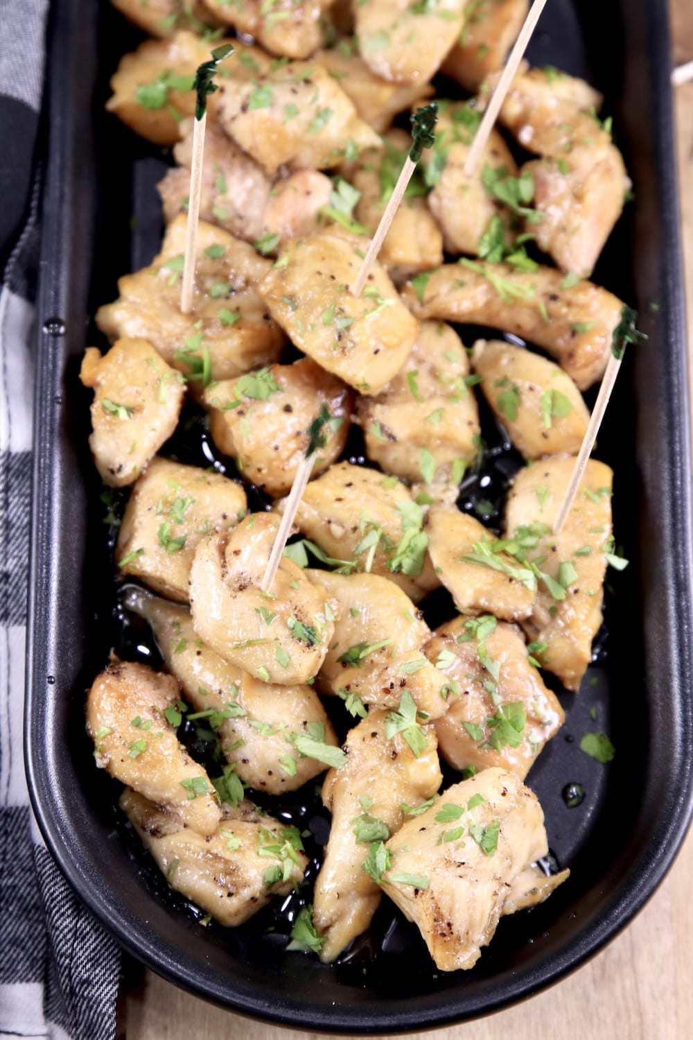 closeup of black tray of chicken bites with toothpicks for serving as appetizers