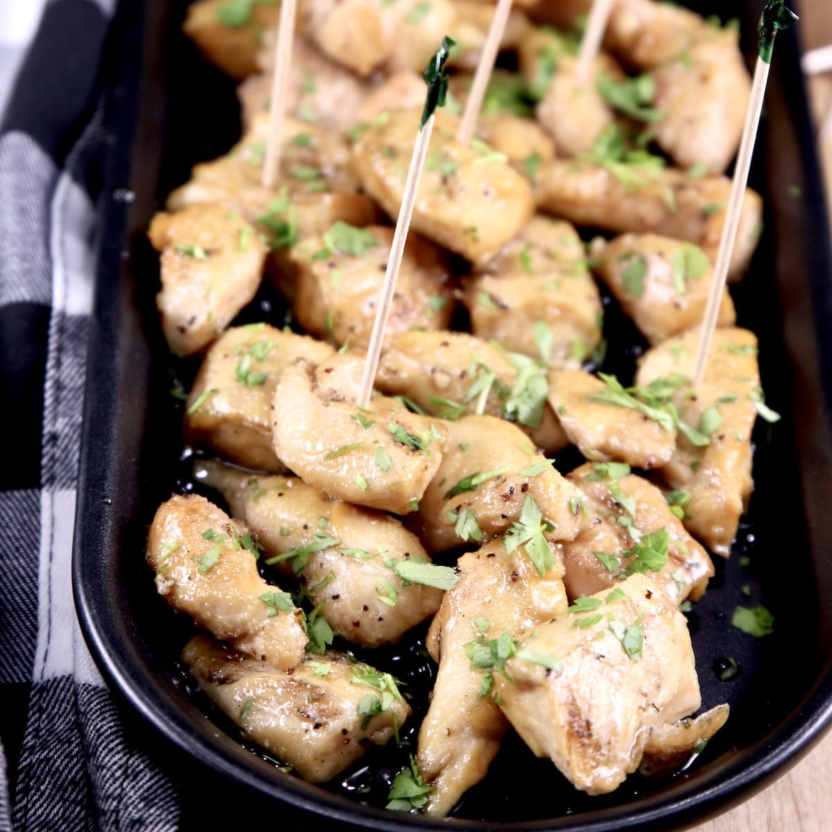 Honey Garlic Chicken Bites on a platter - some with toothpicks for serving