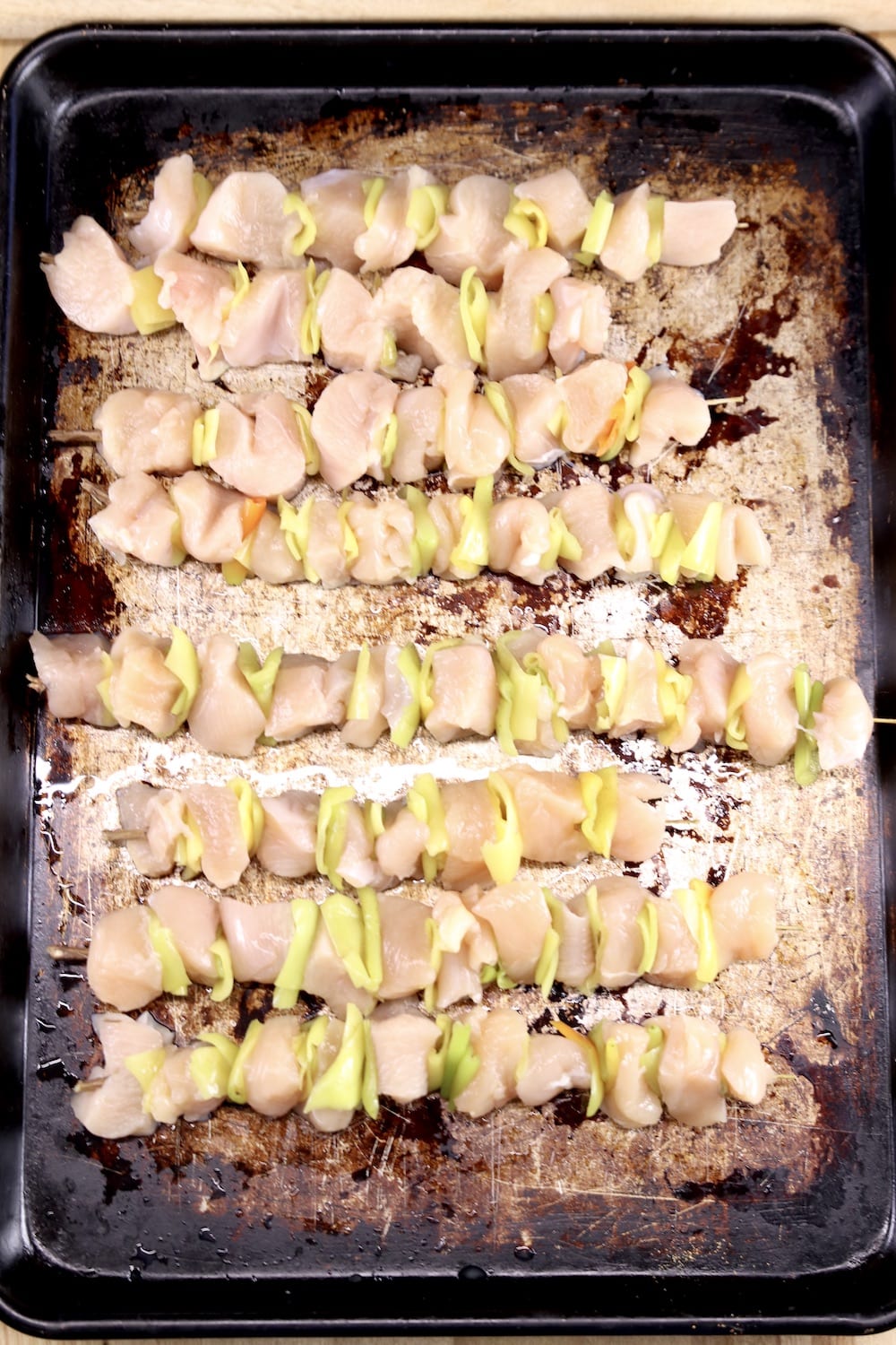 sheet pan with chicken and pepper skewers ready to grill