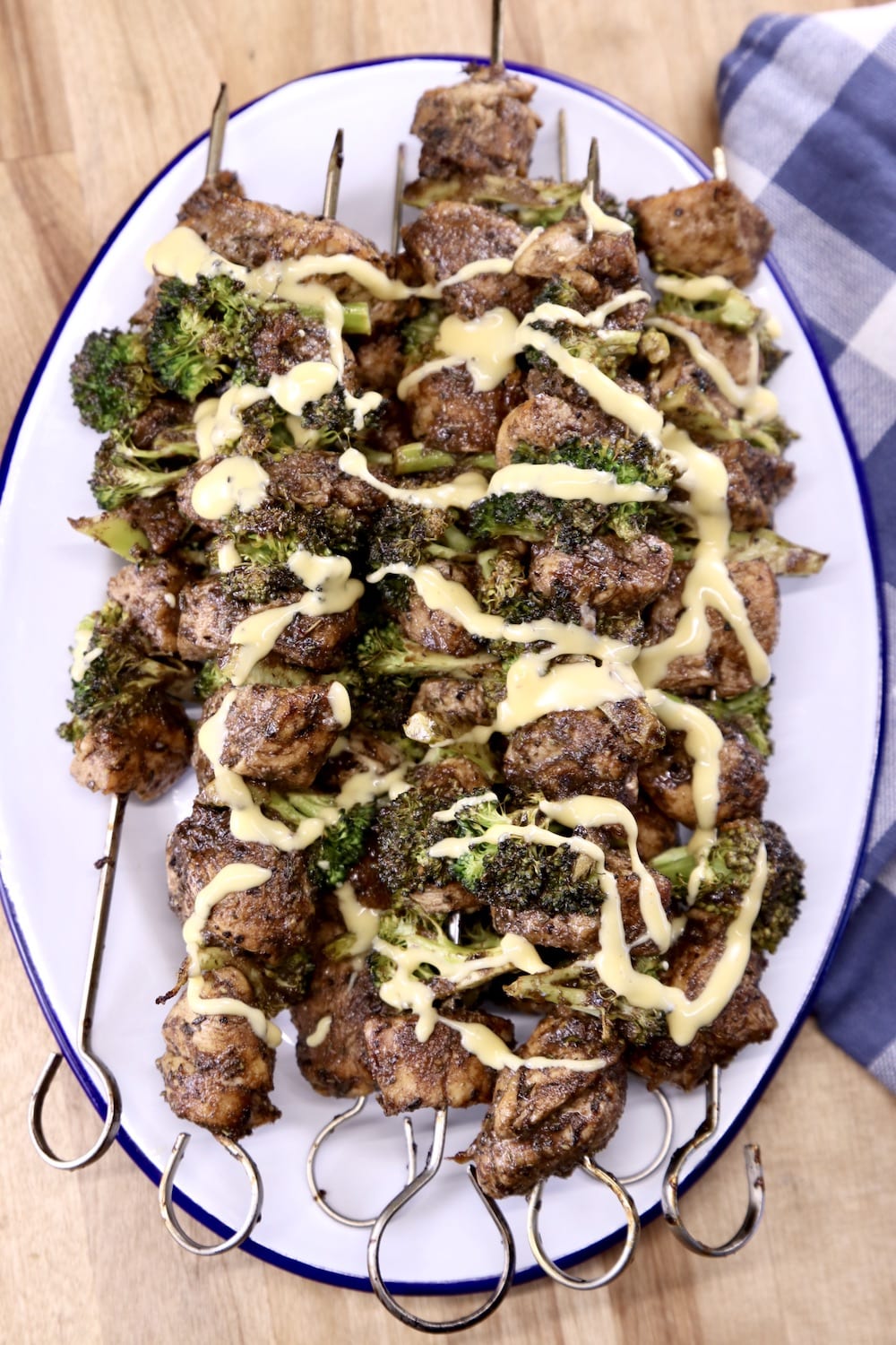 Platter of chicken kabobs with broccoli and cheese