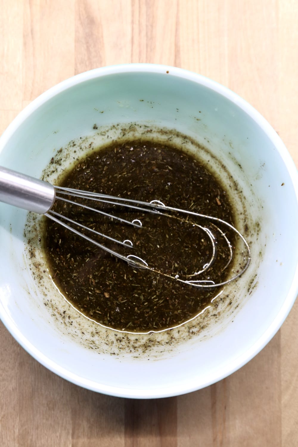 balsamic marinade for chicken in a bowl with a whisk