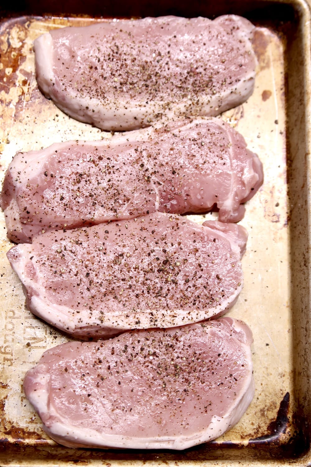 sheet pan with 4 pork chops for grilling 