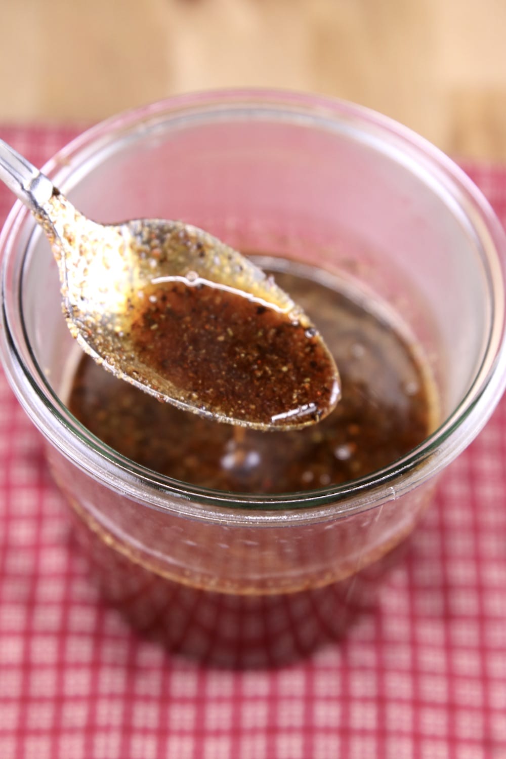glaze for maple chicken wings in a jar - spoon dipping into sauce