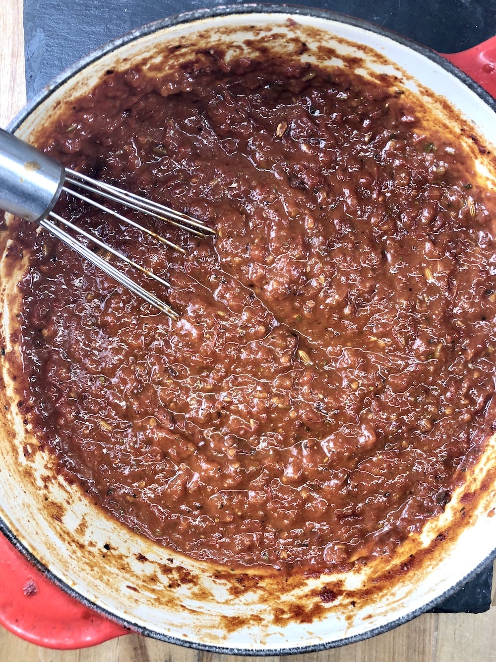 marinara sauce in a pan with a whisk