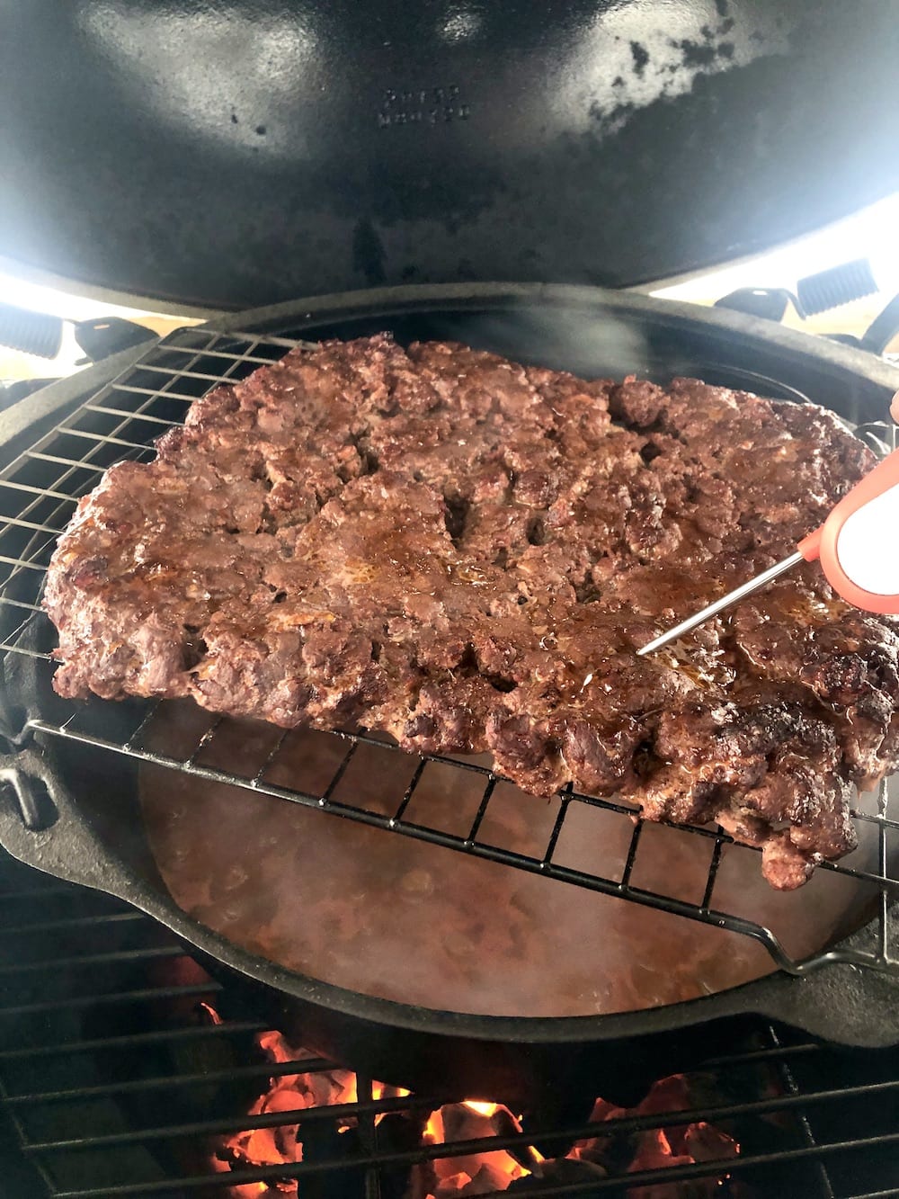 Checking chili meat on the grill with thermometer