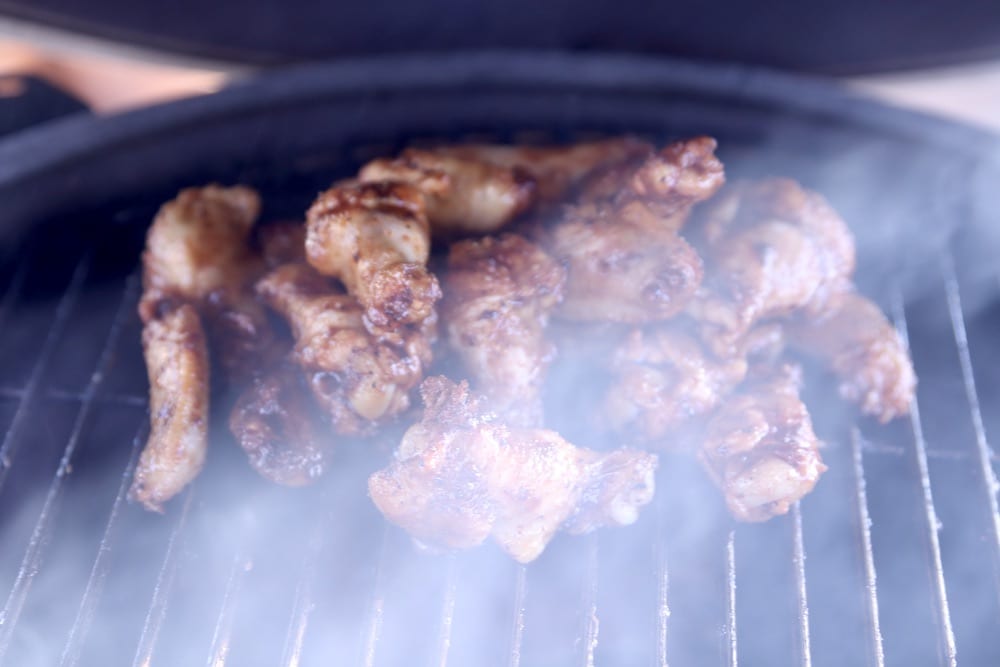 Grilling chicken wings with pecan wood smoke