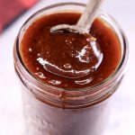 Sweet and Tangy BBQ Sauce in a jar with a wooden spoon