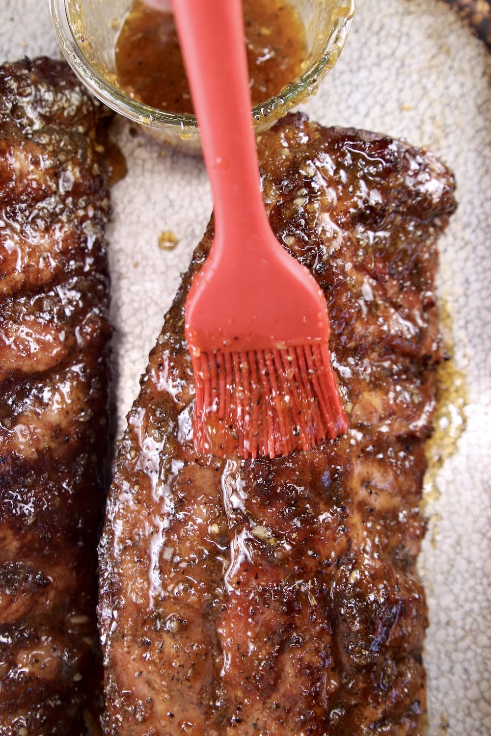 brushing sauce on grilled ribs