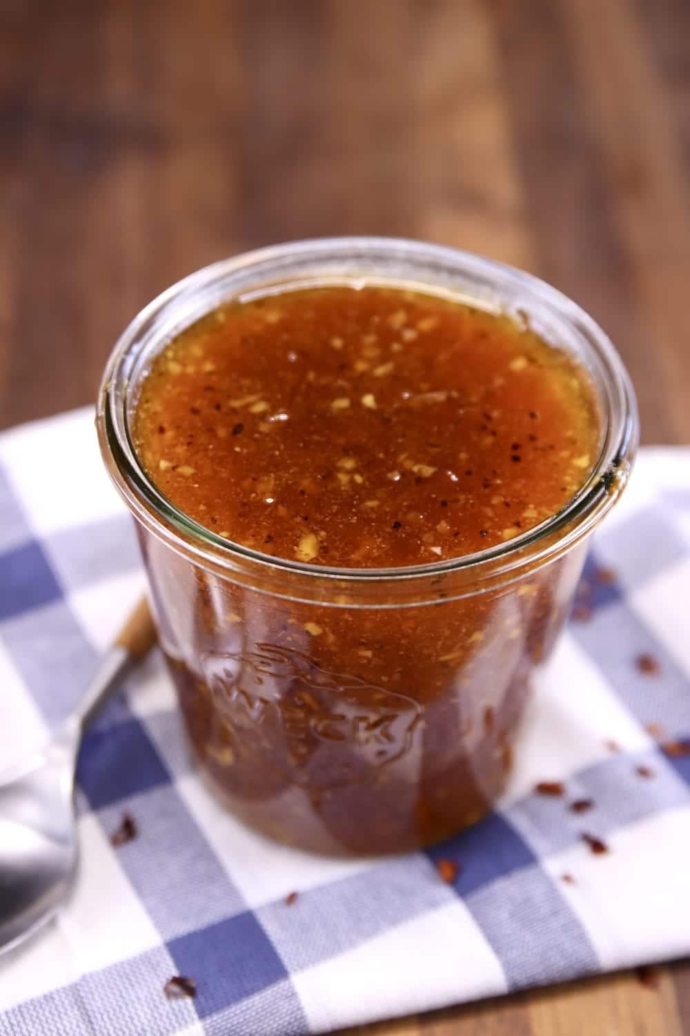 Apricot BBQ Sauce in a jar on a blue and white check napkin
