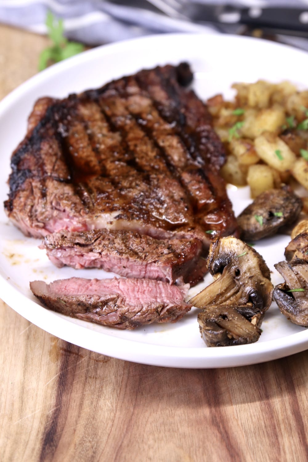 plate with grilled ribeye, potatoes, mushrooms