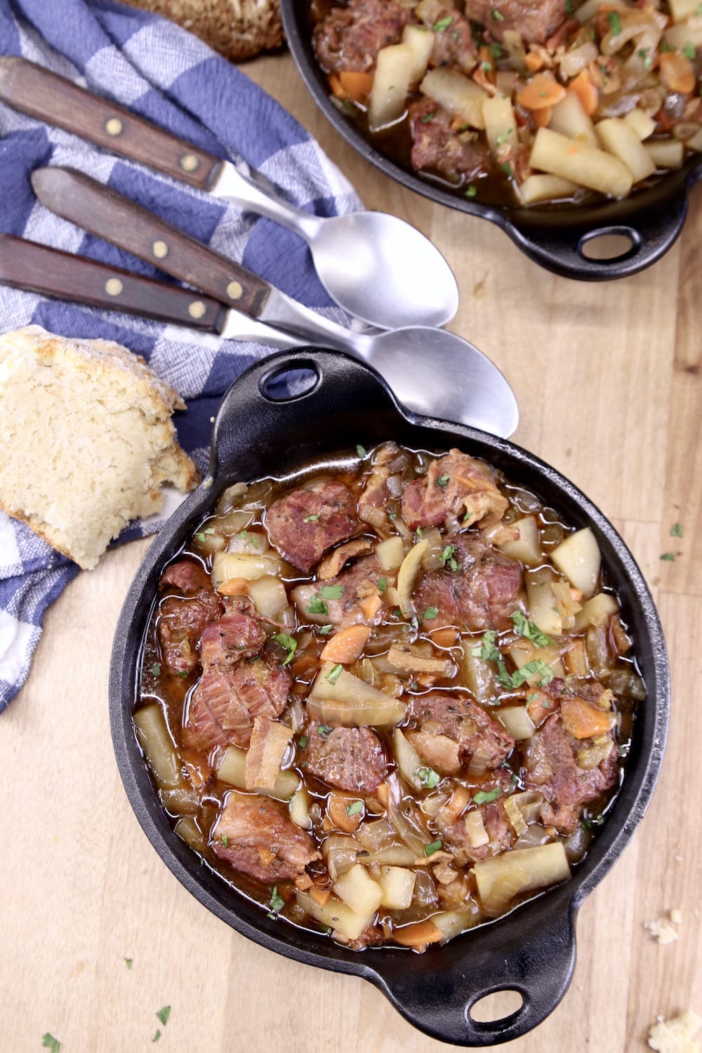 Irish beef stew in a small cast iron serving skillet with soda bread