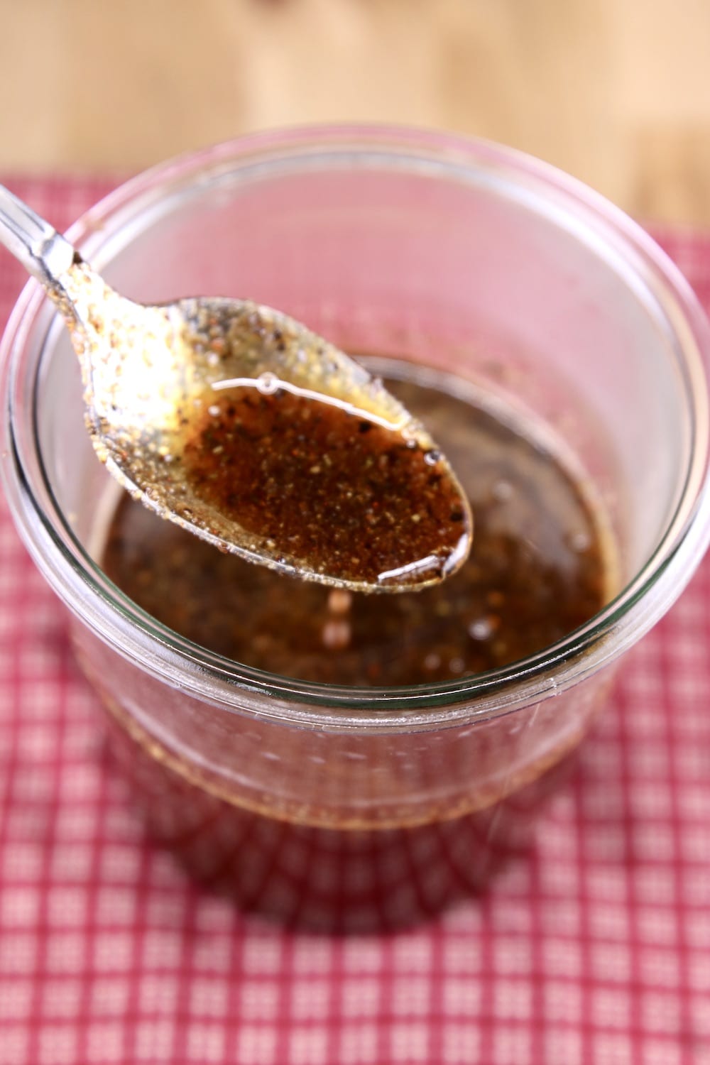 Maple Glaze in a jar with spoon dipping - red napkin background