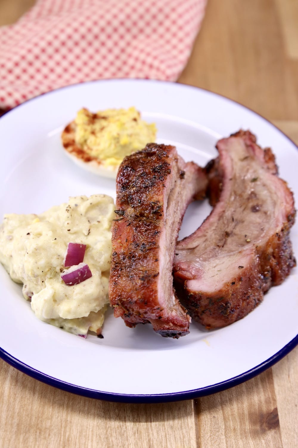 Plate with 2 baby back ribs, potato salad and deviled egg